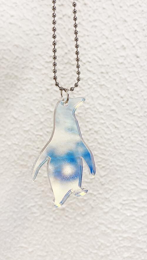 Penguin shaped pendant made from iridescent acrylic.
